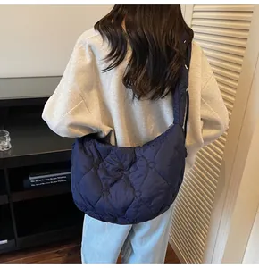 Vue détaillée du matelassage en forme de cœur et de la fermeture de ce sac bleu marine