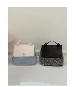 Detail of color-block and black bags featuring crystal embellishments and knotted handles