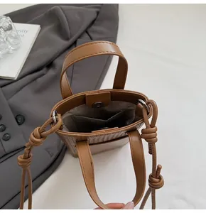 Close-up of minimalist brown bucket bag interior with magnetic snap and inner pocket
