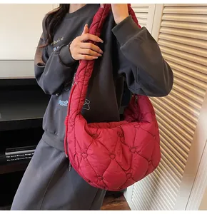 Détail macro du sac à bandoulière rouge matelassé avec motif cœur et texture gonflante