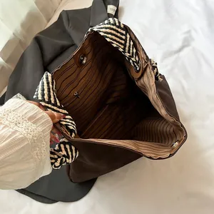 Grand sac cabas marron avec bandoulière tissée et doublure rayée pour femme chic