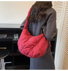 Détail d'un sac matelassé rouge à motif cœur porté à l'épaule pour un look mode