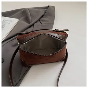 Vue de dessus du sac à main en daim marron montrant la doublure grise et l'espace interne