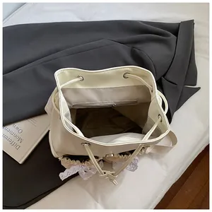Top view of cream bucket bag showing inner drawstring, grey lining, and zipper pocket