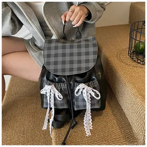 Detail of preppy backpack with lace bow and grey plaid flap on model in use