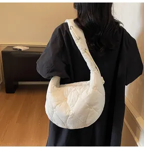 Détail du matelassage en forme de cœur sur un grand sac à bandoulière blanc porté