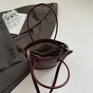 Vintage burgundy woven bucket bag with top handle and internal zipper pocket