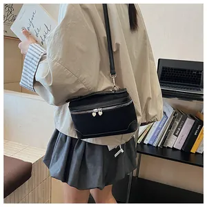 Détail du sac bandoulière noir avec fermeture éclair en forme de cœur et sangle réglable