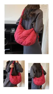 Détail du sac matelassé rouge avec motif cœur montrant la texture en nylon