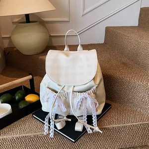 Chic beige backpack with checkered flap and lace bows on a warm indoor setting