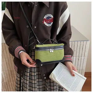 Détail du mini sac à bandoulière vert avec bordure noire et fermetures éclair en forme de cœur