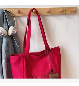 Detail of red canvas tote bag with dog embroidery and sturdy comfortable handle