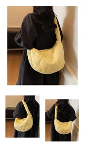Détail du sac croissant jaune clair matelassé avec broderie de motifs de cœur sur nylon