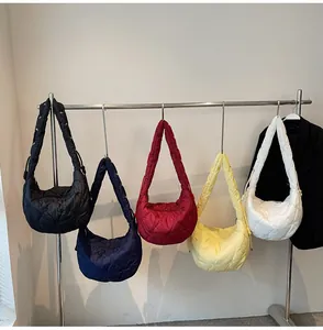 Sacs à bandoulière matelassés en plusieurs couleurs suspendus sur un portant épuré