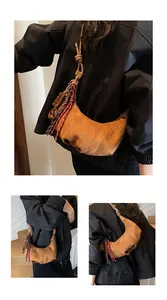 Détail du sac croissant en daim marron avec corde tressée colorée et breloque décorative