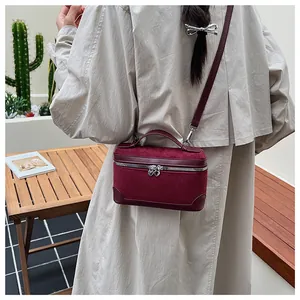 Détail du sac à bandoulière vintage bordeaux avec fermeture éclair en forme de cœur