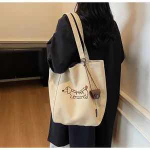 Detail of off-white canvas tote with dachshund embroidery and brown mini card holder