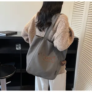 Close-up of charcoal grey canvas tote bag featuring detailed dachshund dog embroidery