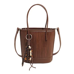 Vintage dark brown woven bucket bag with leather trim and wooden bead tassel accessory