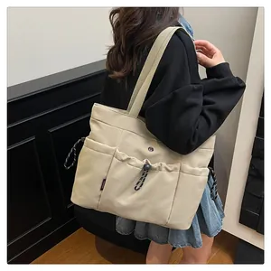 Zijaanzicht van een grote beige Oxford tote tas met trekkoordzakken gedragen door een model