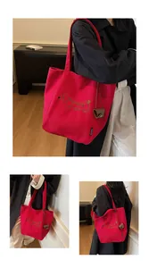 Close-up of red canvas tote bag with dachshund embroidery and stylish heart charm