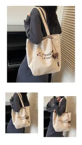 Close-up of beige canvas tote with dachshund print and mini leather pouch detail