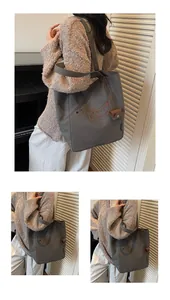 Detailed embroidery of a dachshund on a grey canvas tote bag with side brand label view