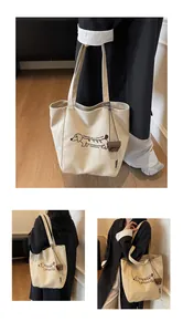 Close-up detail of off-white canvas tote bag with brown dachshund dog print and hanging charm