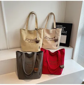 Detail of embroidered canvas tote bags in four colors with cute dachshund illustration
