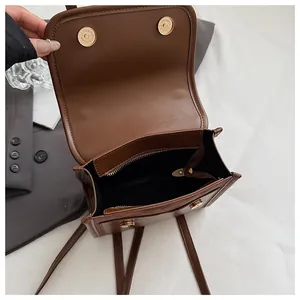Details der Innenseite eines braunen Lederrucksacks mit Gold-Magnetschnallen und Reißverschluss