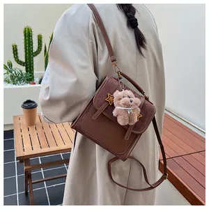 Braune Leder-Umhängetasche mit Stern-Emblem und süßem Teddy-Anhänger im urbanen Stil