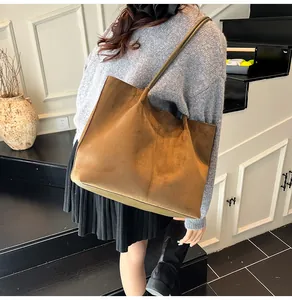 Detail view of large caramel suede tote bag worn on shoulder for minimalist autumn style