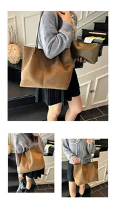 Detail view of a large brown suede tote bag and olive clutch set with long leather straps