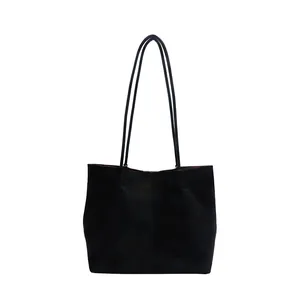 Minimalist black suede tote bag with spacious interior and slender shoulder straps