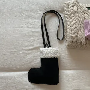 Detail of boot-shaped crossbody bag with soft white faux fur trim and leather strap