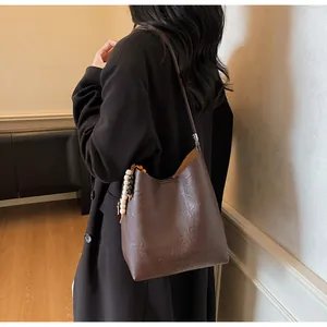Détail d'un sac à bandoulière vintage en cuir marron avec breloques décoratives