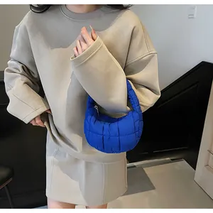 Blue quilted puffer shoulder bag styled with a beige long-sleeve dress outfit