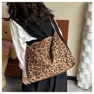 Dettaglio della grande borsa tote leopardata in pelle scamosciata portata a spalla