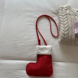 Detail of Christmas stocking crossbody bag with faux sheepskin trim on textured background