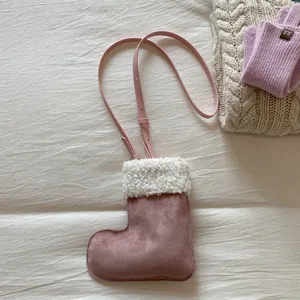 Detail of pink faux suede boot-shaped crossbody bag with white plush trim and strap