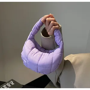 Detailed macro view of a light purple quilted puffer bag with chic square stitching pattern