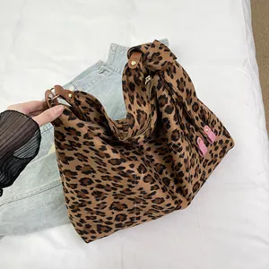 Dettaglio della borsa tote leopardata con cinturini in pelle e rivetti in metallo decor
