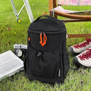 Detail der schwarzen Nylon-Reisetasche mit orangefarbenem Kordelzug und Tragegriffen