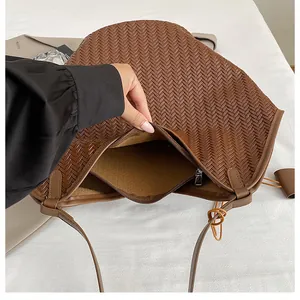 Dettaglio dell'interno della borsa intrecciata marrone con fodera in pelle e zip metallica
