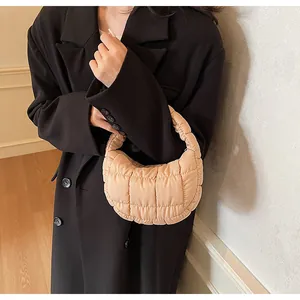 Quilted beige puffer hobo bag detail showing the soft texture and crescent shape design