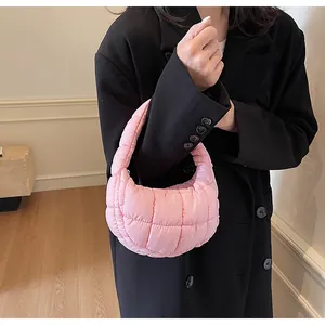 Detail view of pink quilted down shoulder bag showing puffy texture and nylon fabric finish
