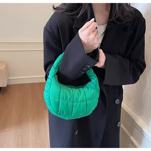 Close-up of bright green quilted down handbag with nylon fabric and zip closure