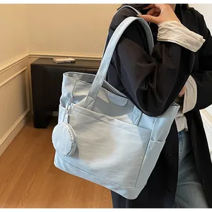 Detail of light blue tote bag with matching zipper pouch and textured fabric surface