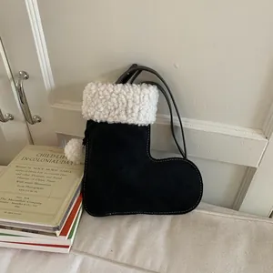 Chic black and white boot-shaped crossbody bag with plush faux fur trim and pom-pom detail