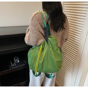 Rückansicht des grünen Kordelzug-Rucksacks mit Nylon-Struktur und gelben Kordel-Details